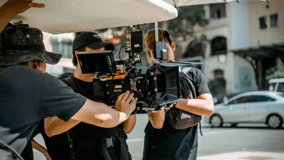 Film production crew setting up lights and cameras on a movie set during filming.