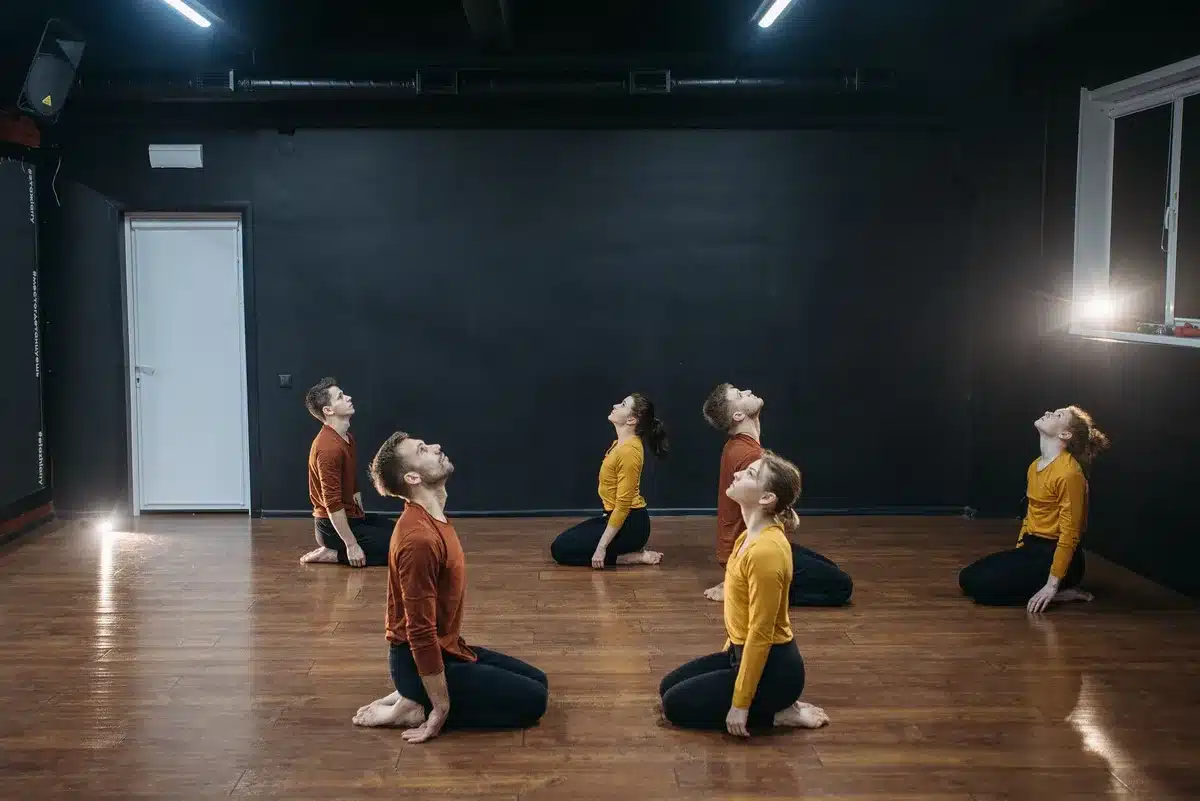 Mehrere Tänzer üben eine Gruppensequenz in einem Tanzstudio