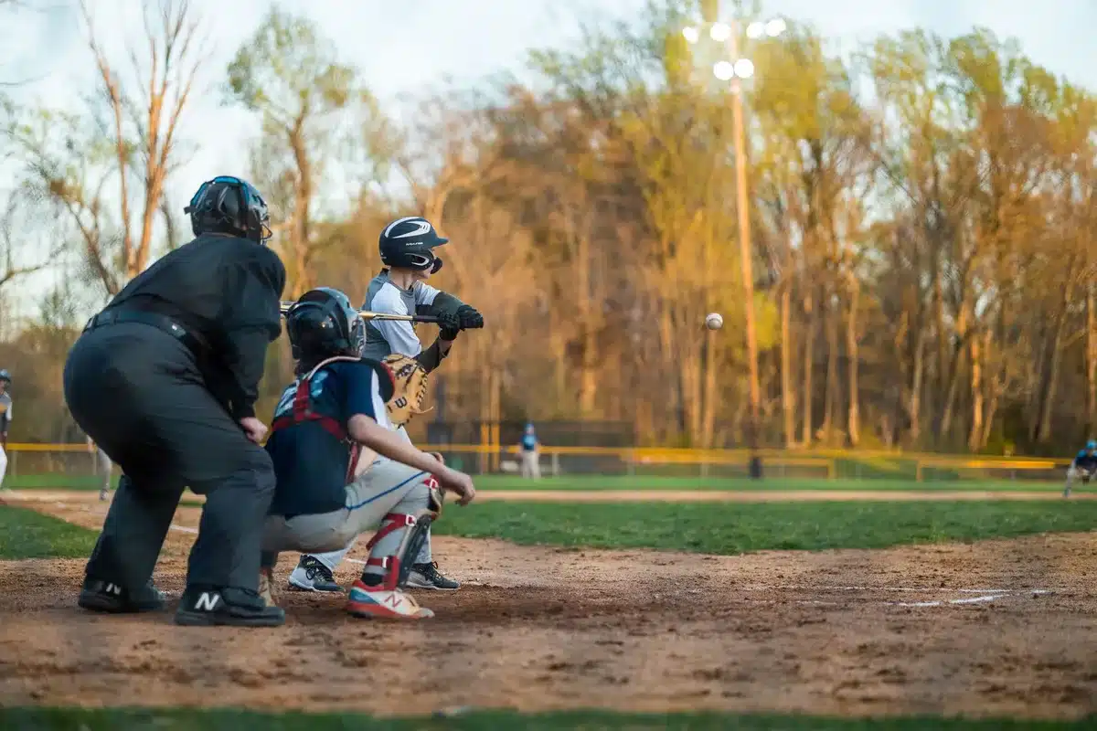 Baseball catcher in gear crouching behind home plate during a night game