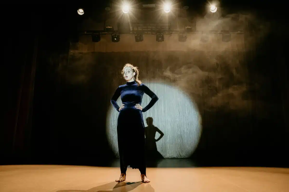 Vintage variety theatre stage with performer under warm spotlights