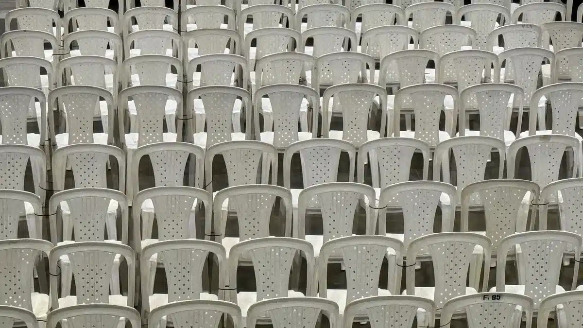 Empty arena seats with a person checking their phone for tour date updates