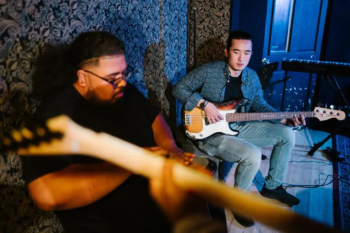 Künstler mit Gitarre in minimalistischem Studioraum während einer intimen Aufnahmesession