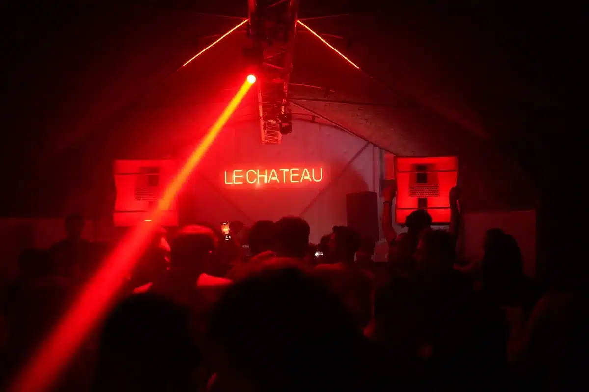 Silhouetted figure in a neon-lit Miami nightclub surrounded by younger dancers, capturing generational clash