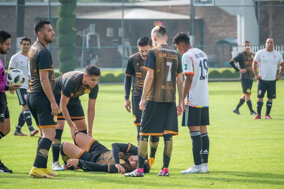 Medical staff attending to a football player on the sideline during training