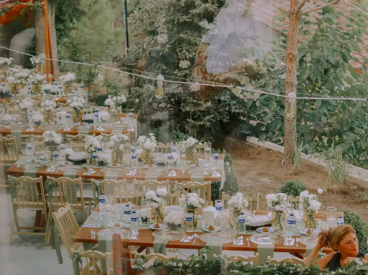 Dimly lit dinner table with two anonymous silhouettes facing each other, wine glasses and place settings visible, tense