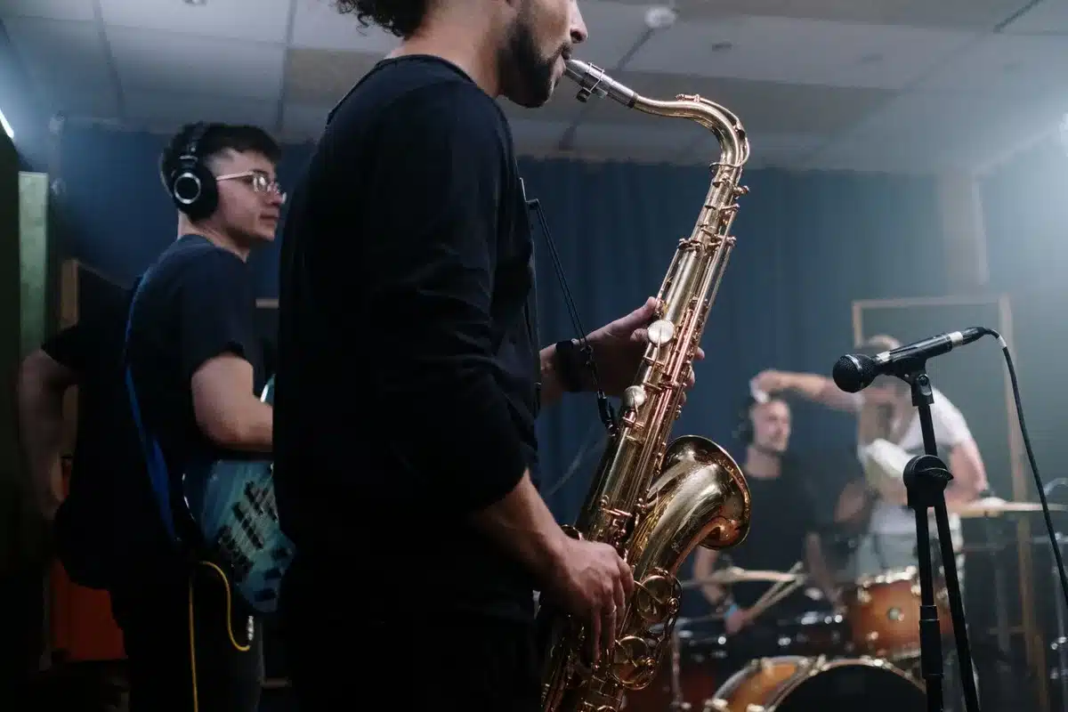 Musicians recording together in a studio with guitars, bass, and drums