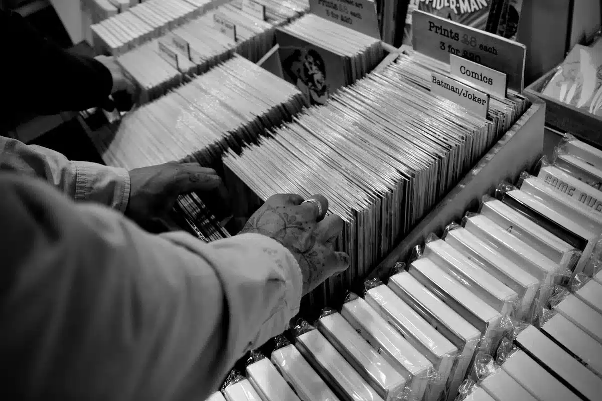 Collector examining comic book covers and variant editions in personal collection