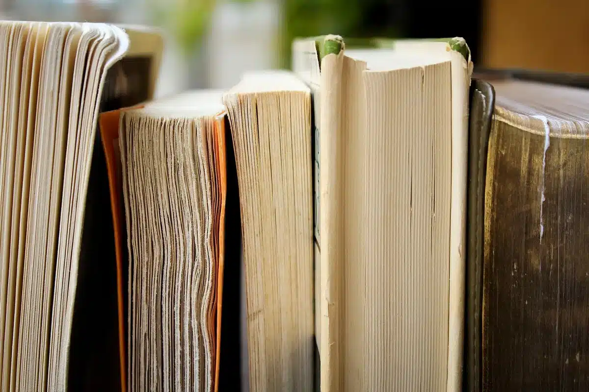 Close-up of a worn paperback comic on a wooden table, a torn page corner and a penciled margin note visible, no names or logos