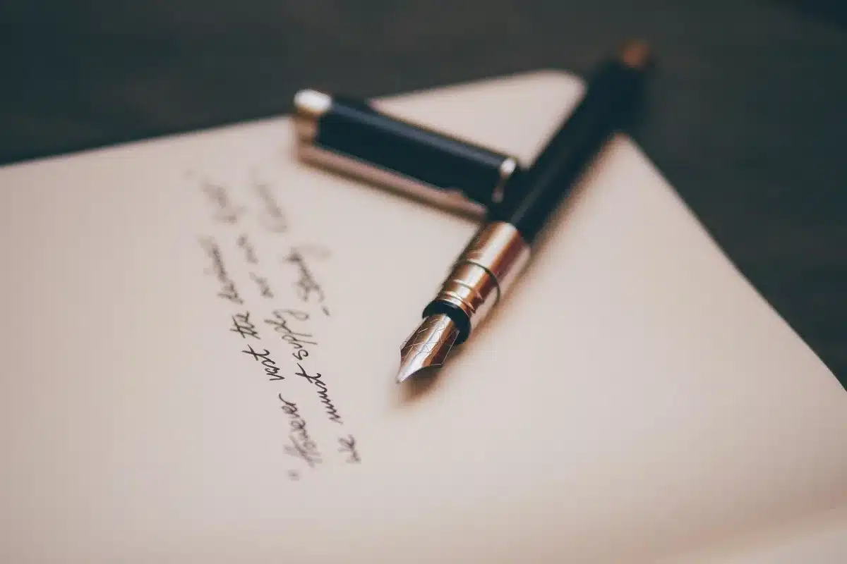 A close-up of a director's hands holding a script, fingers marked with annotations and scribbles, a coffee cup and pencil nearby on a wooden table, soft morning light through a window.
