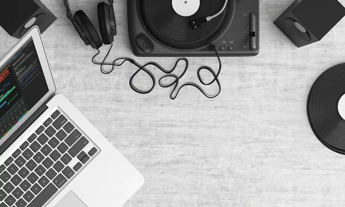 A dimly lit record-store listening corner with an anonymous customer leaning toward a turntable, an unbranded vinyl sleeve propped nearby and a record needle poised over the platter — tension