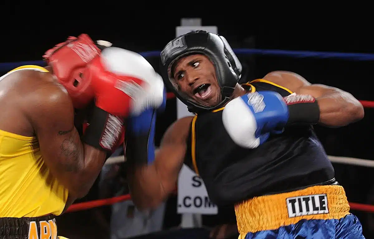 Empty ring with a single boxing glove on the canvas under a spotlight, faint crowd silhouettes in the dark background