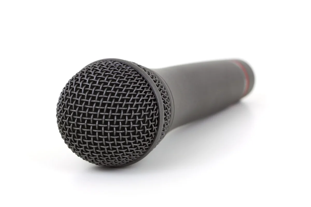 Voice actor in recording booth with microphone and script (anonymous)