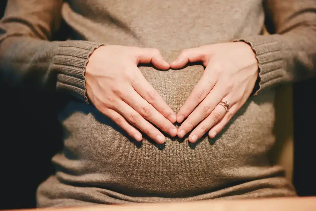 A woman holding her stomach in a tense moment