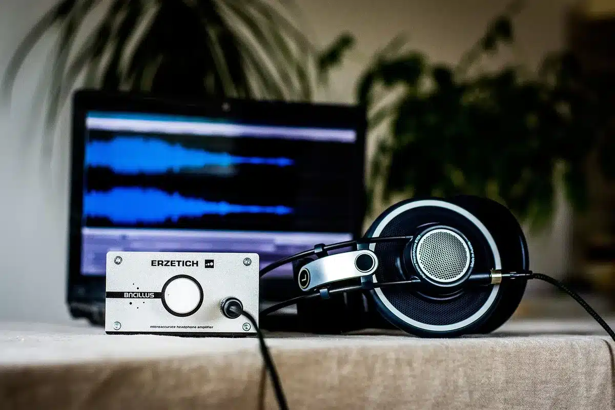Hands holding a notebook surrounded by vinyl records and headphones on a desk