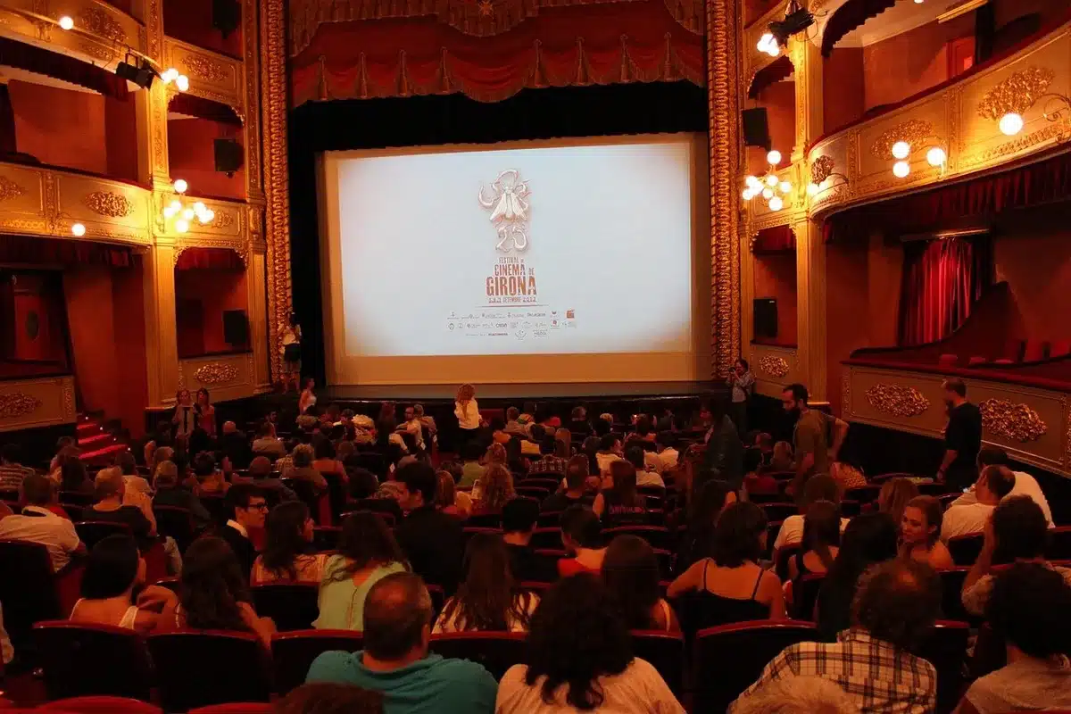 Spectateurs assis dans une salle de cinéma regardant un film projeté