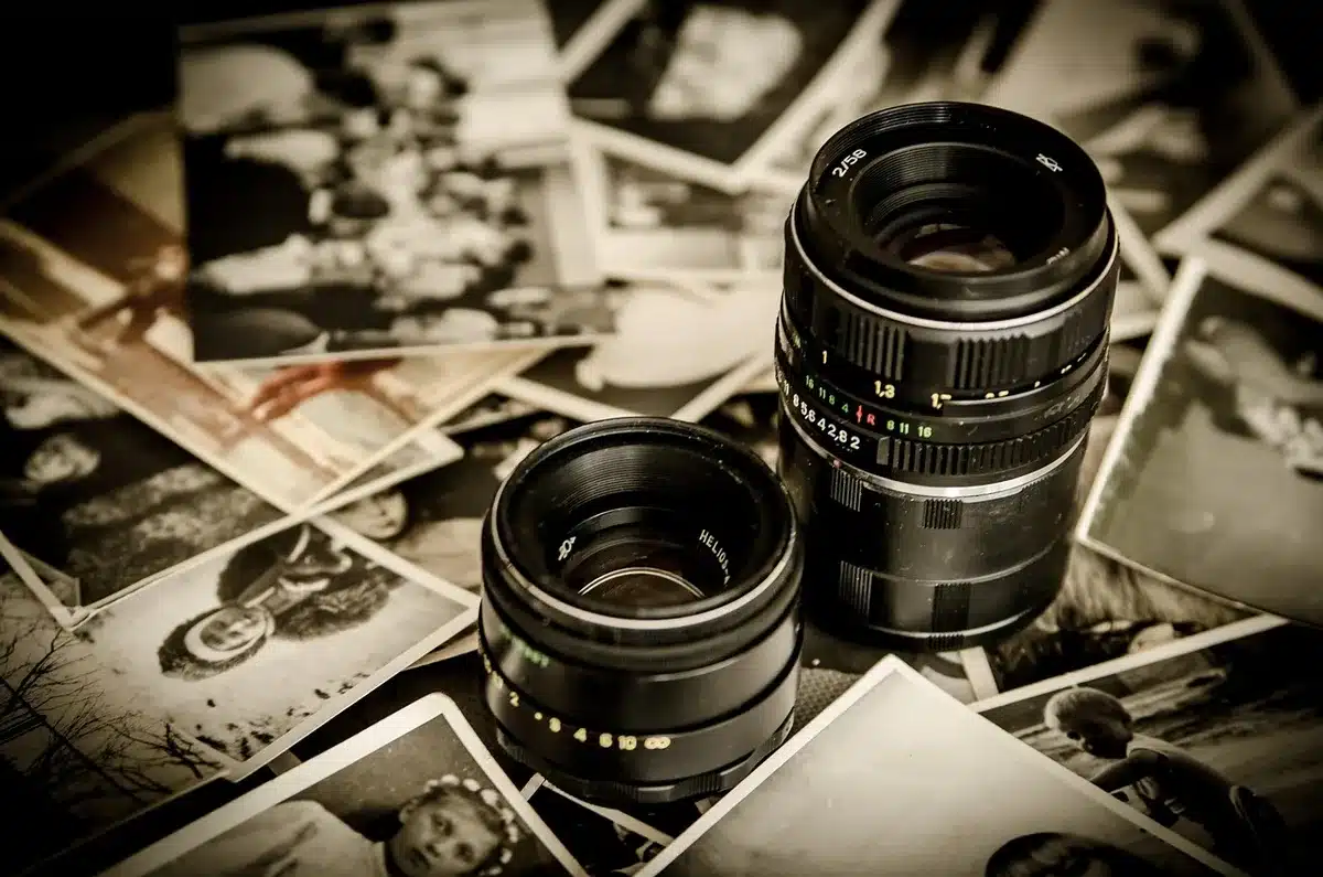 A close-up of vintage film reels and early cinema equipment in soft focus, dust particles visible in light, archival aesthetic