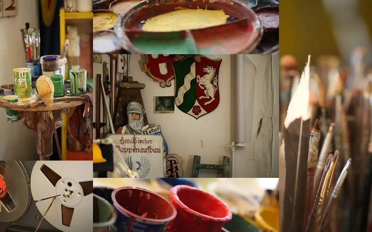 Hands arranging collage artwork in a studio for a music video
