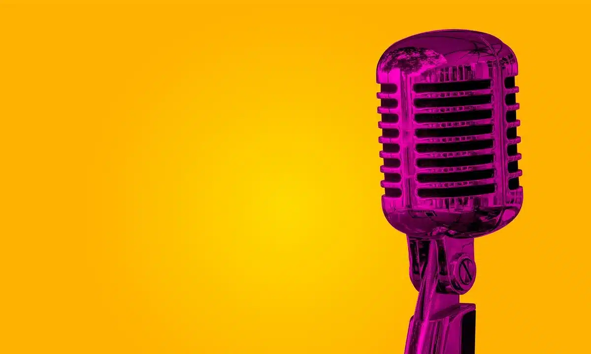empty stage with single spotlight and a lone vintage microphone on a stand, dust motes in the beam