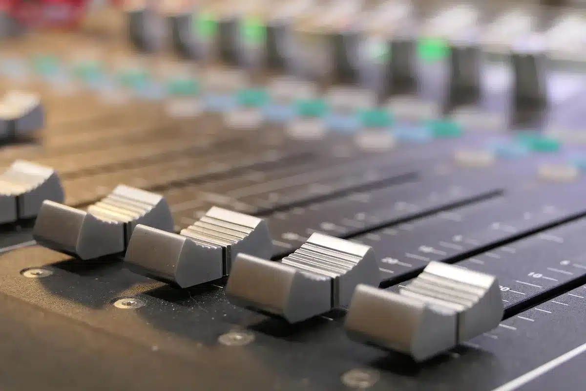 Musicians working around a mixing console in a recording studio