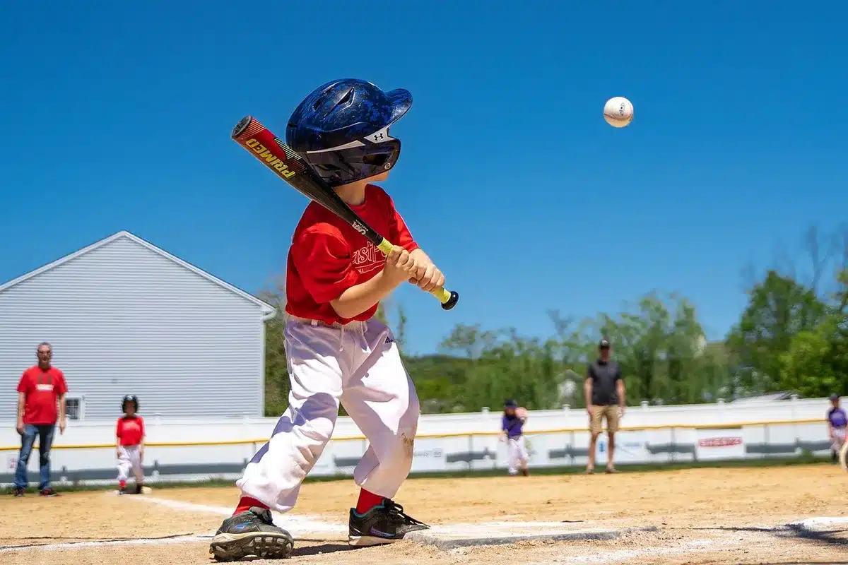 Young baseball player in Yankees uniform preparing to bat in outfield position