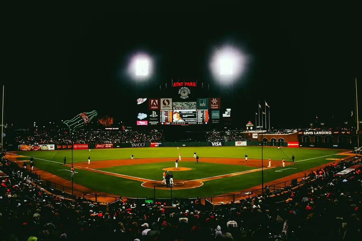 Baseball stadium interior during evening game with crowd in seats