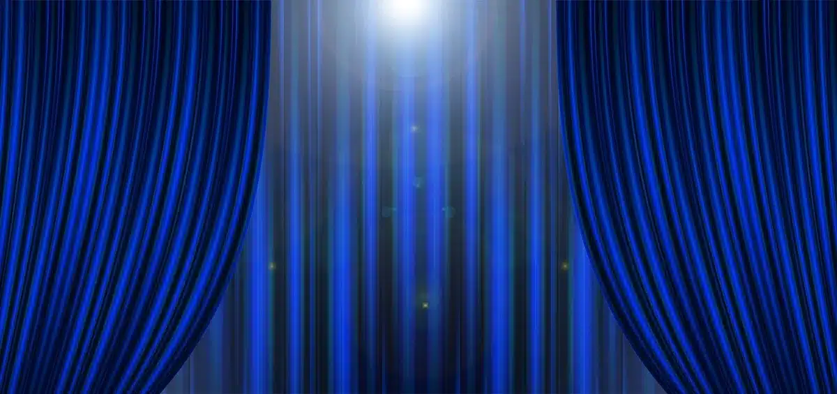 Empty vintage movie theater with a single spotlight on a blank screen and an old film poster pinned to the wall, no people visible