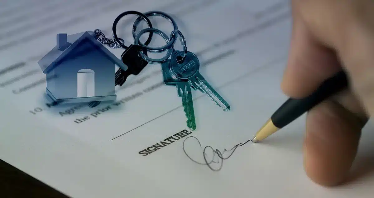 Close-up of a treble staff on manuscript paper showing three sharps at the key signature, a pencil marking a starting chord, shallow depth of field