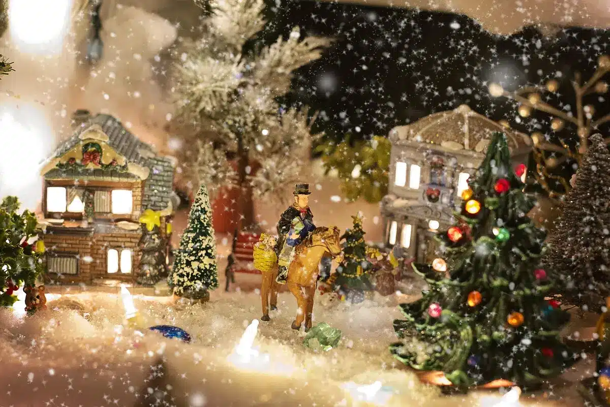 Miniature diorama of a suburban street with a handcrafted forest edge and tiny puppet boots