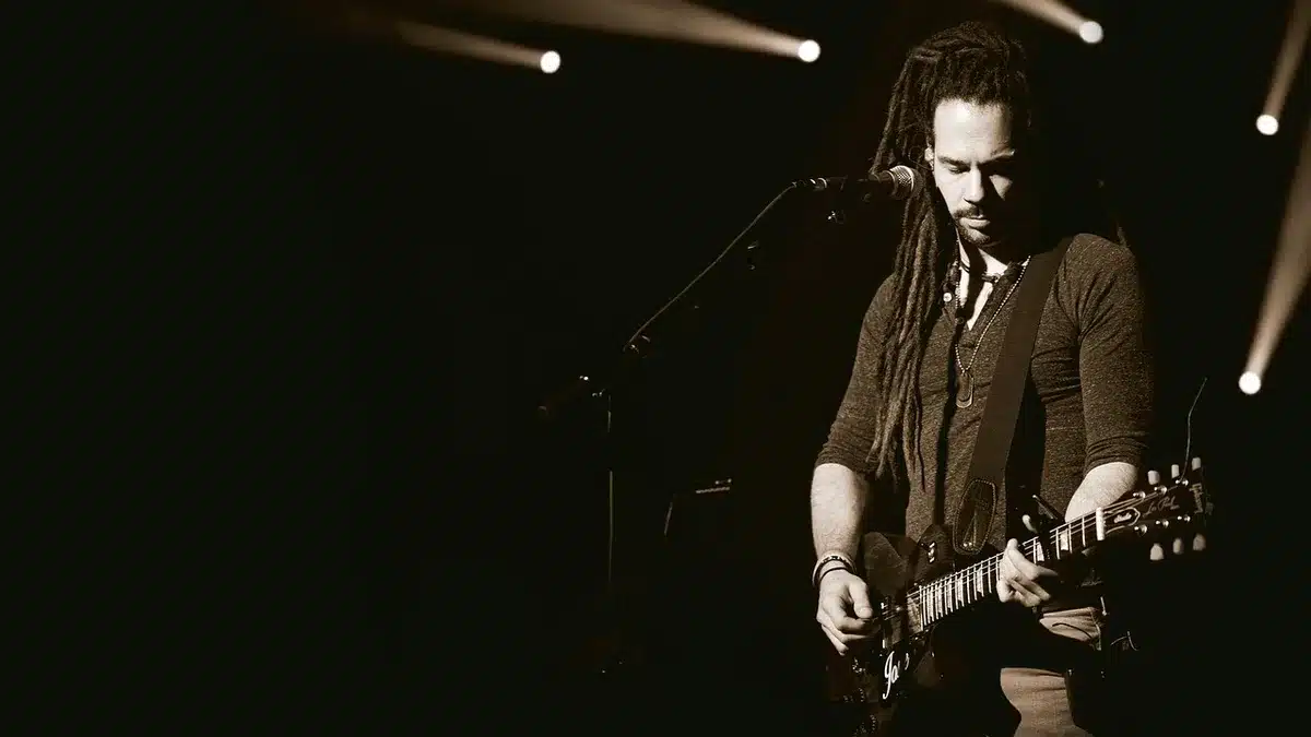 Silhouette of a guitar on an arena stage with scattered confetti and empty seats