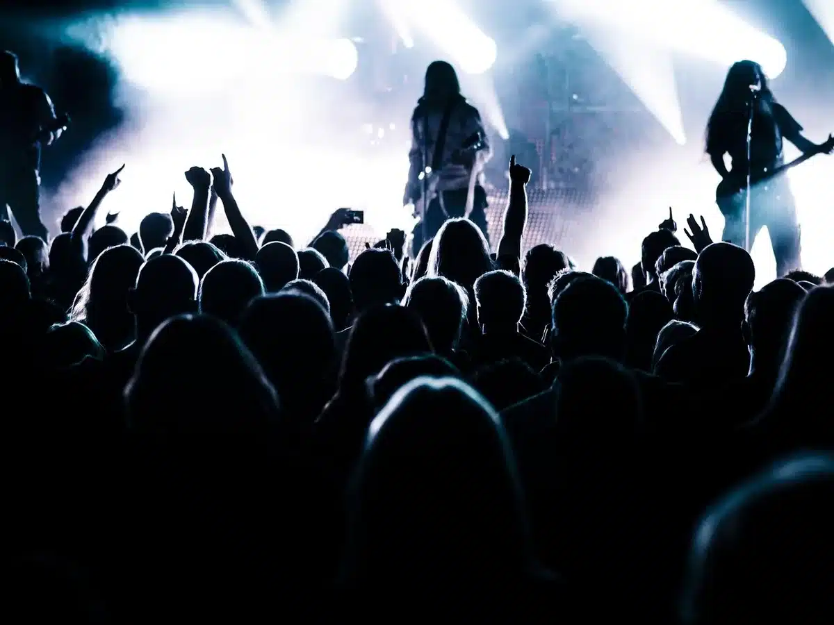 Silhouette of a performer on stage facing a blurred audience
