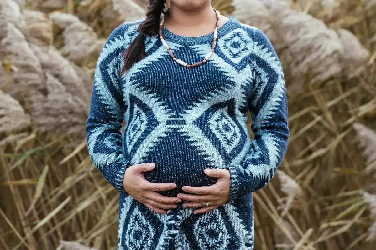 Maternity photo with hands holding ultrasound and flowing white dress