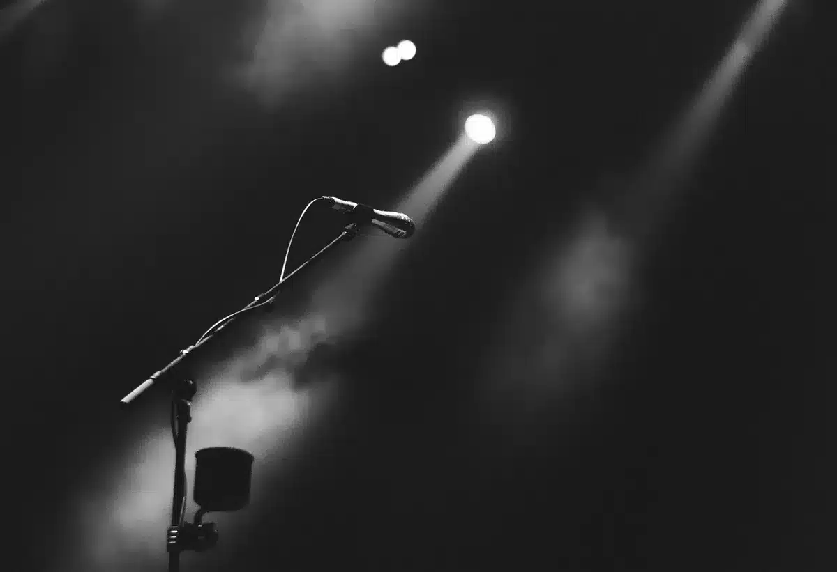 Empty stage with microphone and instruments lit, suggesting lineup change