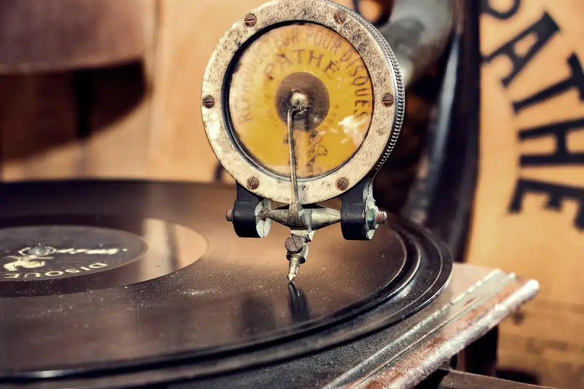 A tidy spread of unbranded vinyl records and a paper playlist on a table, no logos visible, with a coffee cup at the edge