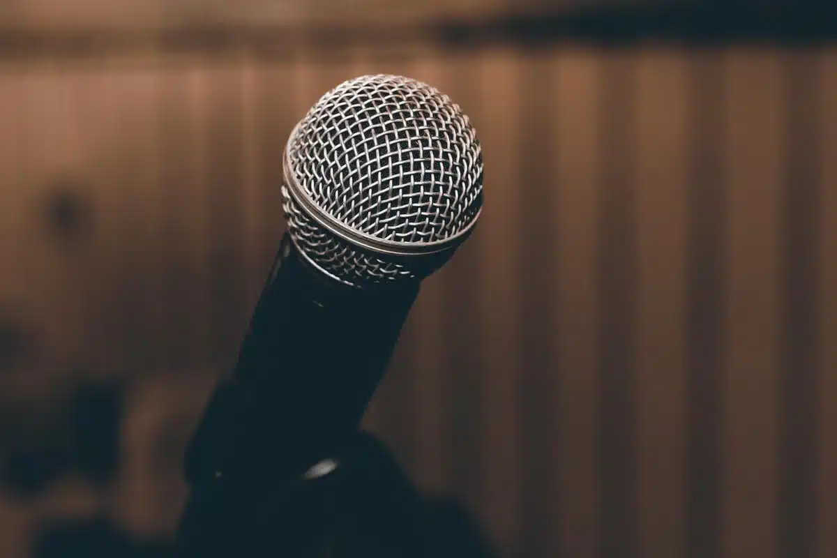 Two microphones in a dim studio suggesting a recorded duet