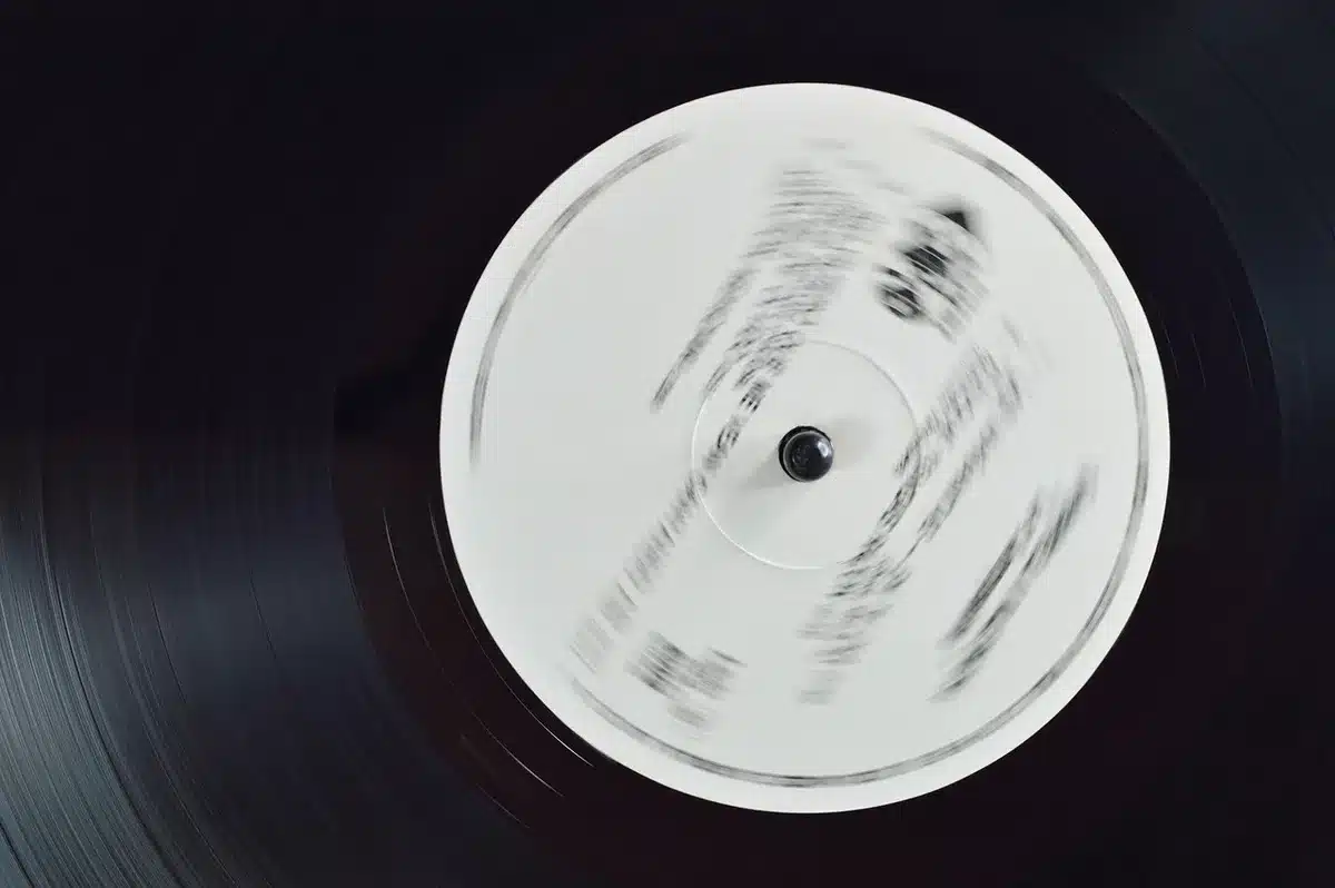 Hands holding a record contract near a label logo on a desk