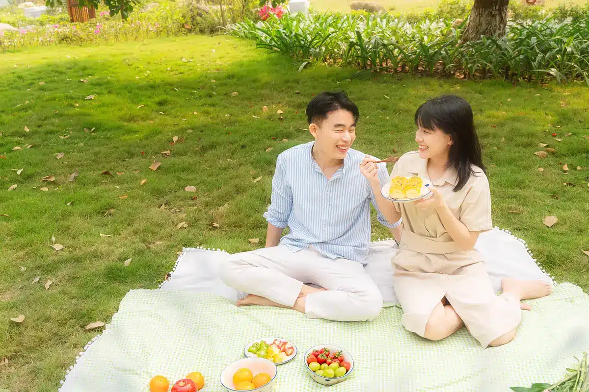 Mary and Tom at a Regency-era picnic, hands touching on a blanket