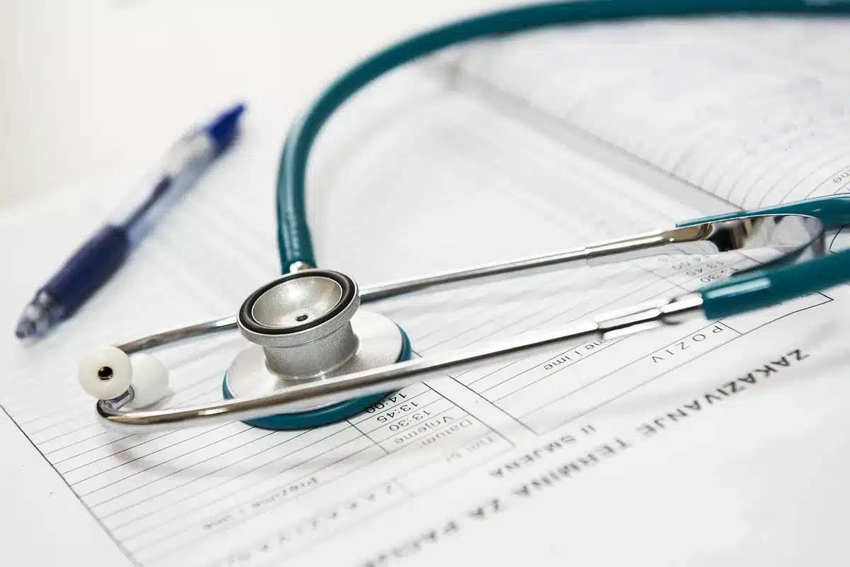 Stack of official medical records and a coroner's report on a desk