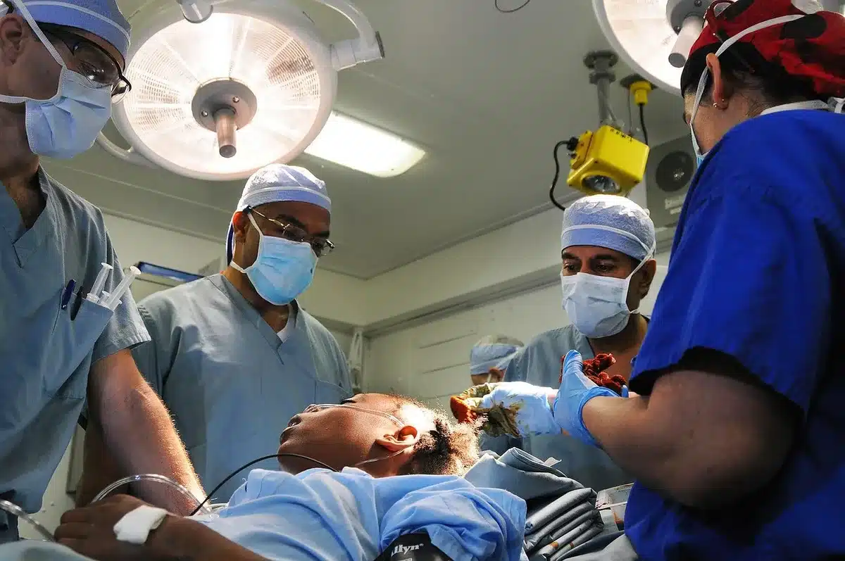 Patient in surgical gown and cap sitting in a hospital bed